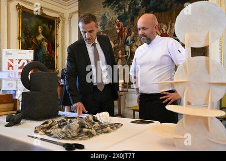 Praga, Repubblica Ceca. 12 aprile 2024. L-R Ambasciatore francese in Repubblica Ceca Stephane Crouzat e chef in residenza presso l'Ambasciata francese Alexandre di Cintio guardano un creativo menu a buffet franco-ceco, prima di una degustazione presso l'Ambasciata francese nell'ambito dell'evento globale Gout de France/Good France, che mira a promuovere la Francia attraverso la sua cucina, a Praga, Repubblica Ceca, il 12 aprile 2024. Crediti: Michal Kamaryt/CTK Photo/Alamy Live News Foto Stock