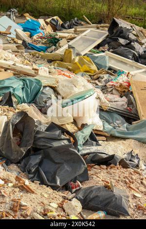 Immergiti nel paesaggio inquietante del degrado urbano e del degrado ambientale con questa suggestiva immagine di una montagna di rifiuti in una fabbrica abbandonata Foto Stock