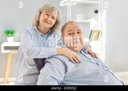 Felice famiglia anziana coppia moglie e marito seduti sul divano nel soggiorno di casa. Foto Stock