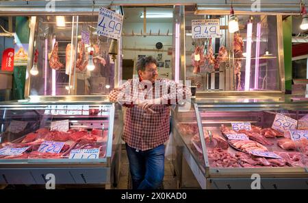 Macellaio, commerciante di carne che si posa orgogliosamente davanti al suo bancone, esposizione di carni fresche, macelleria, cibo, mercato Kapani, Vlali, Salonicco, Macedonia, Grecia Foto Stock