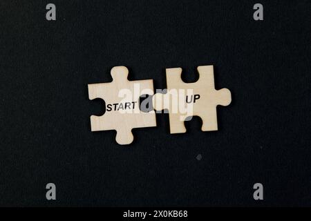 I pezzi del puzzle si intersecano per formare la parola "STARTUP", evidenziando lo sforzo di collaborazione Foto Stock