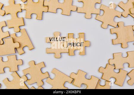 I pezzi di puzzle in legno si assemblano per formare le parole "valore" e "prezzo", a simboleggiare il fatto che considerare entrambi i fattori è fondamentale per il successo. Foto Stock
