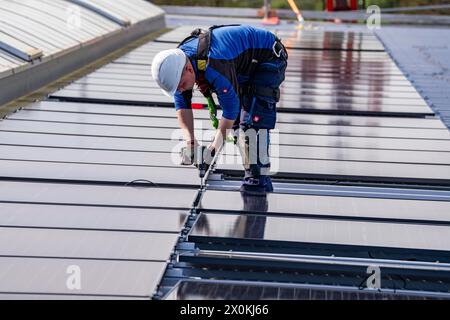Installazione di moduli solari sul tetto di un'impresa commerciale, oltre 400 moduli fotovoltaici sono installati sul tetto, NRW, Germania Foto Stock