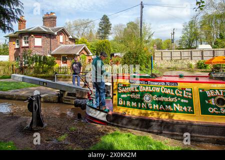 Narrowboat Beatty nella livrea della Samuel Barlow Coal Company Limited, passando davanti a un cottage di guardiani sul canale Shropshire union a Audlem Chesh Foto Stock