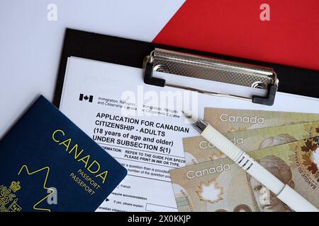Domanda di cittadinanza canadese per adulti sul tavolo con penna, passaporto e banconote da un dollaro da vicino Foto Stock