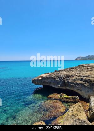 Ammira le rocce e le acque turchesi sul lungomare di Cala Ratjada in una splendida giornata estiva, Maiorca, Spagna Foto Stock