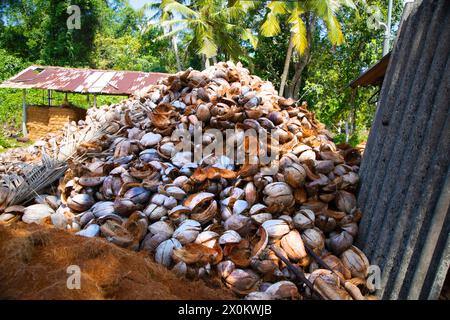 Tre fasi di fabbricazione della corda di cocco con processo tradizionale. Piccola manifattura privata per la produzione di corde da gusci di cocco. grande pila o Foto Stock