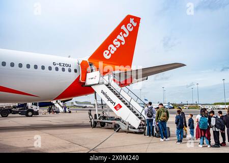 I passeggeri che salgono a bordo di un aereo easyJet a pochi passi dall'asfalto sul retro dell'aeroporto internazionale di Birmingham Foto Stock