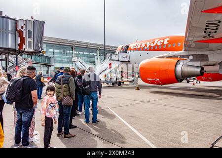 I passeggeri che salgono a bordo di un aereo easyJet a pochi passi dall'asfalto dell'aeroporto internazionale di Birmingham Foto Stock