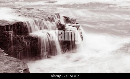 L'acqua scorre dalle grandi rocce di Four Mile Beach, California Foto Stock