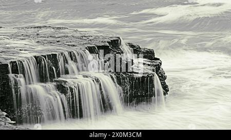 L'acqua scorre dalle grandi rocce di Four Mile Beach, California Foto Stock