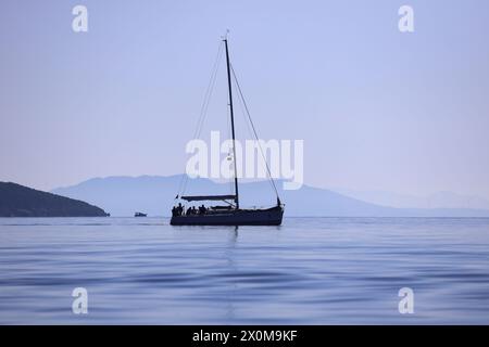 Bodrum, Turchia. 24 febbraio 2024: Le barche a vela navigano con il vento nelle acque blu del Mar Egeo, sulle rive della famosa meta turistica Foto Stock