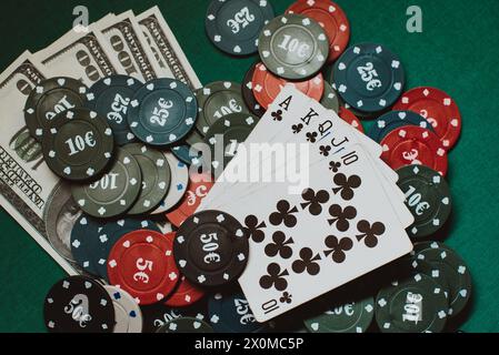 Carte con un colore reale su un mucchio di chip e denaro dollari in un gioco di poker Foto Stock