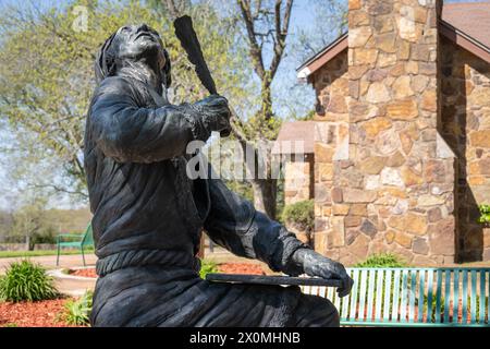 Statua dell'inventore Cherokee dell'alfabeto indiano Sequoyah, che guarda verso l'alto con penna di quill piuma, presso il sito storico Sequoyah's Cabin a Sallisaw, Oklahoma. (USA) Foto Stock