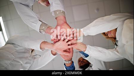 Basso angolo di vista medico Mani di impilamento insieme in ospedale Foto Stock