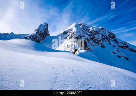 Pendii innevati del paesaggio alpino dolomitico intorno al passo di Giau in inverno, le cime innevate di Torre Dusso e il Monte Cernera in lontananza. Foto Stock