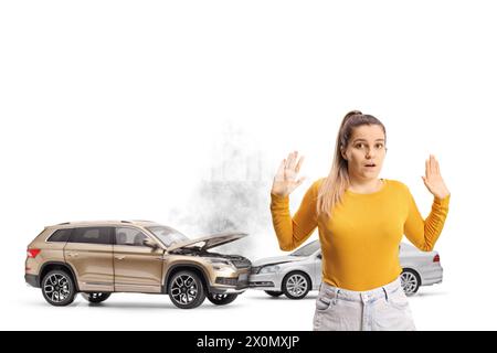 Giovane donna spaventata che assiste ad una collisione d'auto isolata su sfondo blu Foto Stock