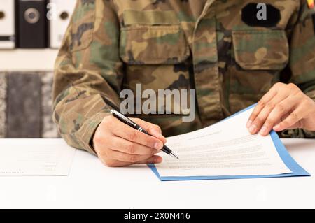 Primo piano dell'uomo militare esecutivo firma il contratto su una scrivania al lavoro Foto Stock