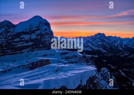 La cima innevata della Tofana di Rozes, circondata da paesaggi alpini dolomitici intorno al passo Falzarego in inverno, vista dal monte Lagazuoi all'alba Foto Stock