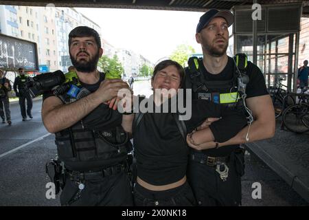 13 aprile 2024, Berlino, Germania: Continuando i loro sforzi per attirare l'attenzione su questioni climatiche urgenti, l'ultima generazione, la Letzte Generation, membri del gruppo di attivisti bloccò Frankfurter Allee, una delle rotte di traffico più antiche e cruciali di Berlino, il 13 aprile 2024. L'ultima generazione, un importante gruppo di attivismo climatico in Germania, è diventato sempre più visibile a causa delle loro proteste di alto profilo e dirompenti rivolte alle principali arterie stradali e agli spazi pubblici. Originatosi come parte di un'ondata globale di attivismo ambientale, il gruppo chiede che il governo tedesco si impegni a più aggressività Foto Stock