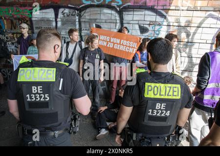 13 aprile 2024, Berlino, Germania: Continuando i loro sforzi per attirare l'attenzione su questioni climatiche urgenti, l'ultima generazione, la Letzte Generation, membri del gruppo di attivisti bloccò Frankfurter Allee, una delle rotte di traffico più antiche e cruciali di Berlino, il 13 aprile 2024. L'ultima generazione, un importante gruppo di attivismo climatico in Germania, è diventato sempre più visibile a causa delle loro proteste di alto profilo e dirompenti rivolte alle principali arterie stradali e agli spazi pubblici. Originatosi come parte di un'ondata globale di attivismo ambientale, il gruppo chiede che il governo tedesco si impegni a più aggressività Foto Stock