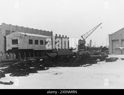 ESTREMO ORIENTE: SINGAPORE, MALESIA E HONG KONG 1939-1945 - Preludio 1939 - 8 dicembre 1941: La base navale di Singapore. Vista di alcune officine e gru. I cavi di ancoraggio sono visibili in primo piano della Royal Navy Foto Stock