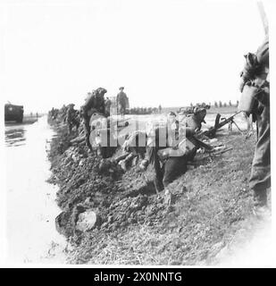 Le truppe dell'Ottava Armata si impegnano nella preparazione difensiva a una testa di ponte, scavando in un terreno morbido e fangoso. Il negativo fotografico documenta le operazioni sul campo. Esercito britannico. Foto Stock