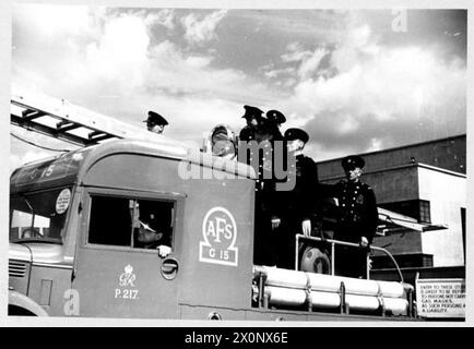 AFS FILM ACTORS: LE RIPRESE DI "STORIA INEDITA" AI DENHAM FILM STUDIOS, DENHAM, BUCKINGHAMSHIRE, INGHILTERRA, REGNO UNITO, 1941 - gli uomini del servizio antincendio ausiliario di Uxbridge lasciano i Denham Studios sul loro apparecchio al sole, dopo le riprese del film "Unpublished Story" della Two Cities Film Company. Il film è diretto da Harold French e interpretato da Richard Greene e Valerie Hobson. È ambientato durante il Blitz sui moli di Londra nel 1940 Foto Stock