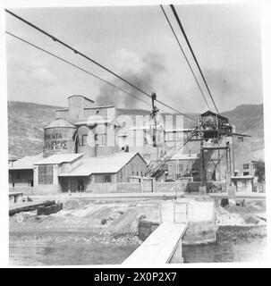 LE FABBRICHE RIAPRONO IN GRECIA - Vista della fabbrica di cemento fuori Volos, dal molo di carico. I cavi sospesi trasportano i carrelli alla dalla fabbrica. Negativo fotografico, British Army Foto Stock