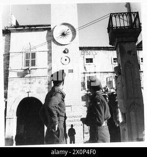 Un orologio cittadino in Jugoslavia visualizza l'ora con gli slot numerici retroilluminati di notte. Il negativo fotografico documenta le infrastrutture locali durante le operazioni dell'esercito britannico. Foto Stock