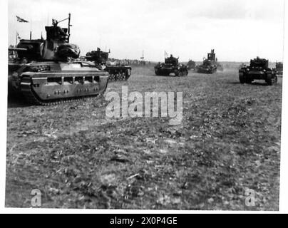 Il re esamina una divisione corazzata mentre i carri armati passano la base salutistica. Negativo fotografico, British Army. Foto Stock