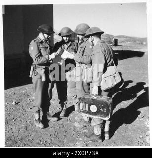 L'ESERCITO BRITANNICO NELLA CAMPAGNA IN TUNISIA, NOVEMBRE 1942-MAGGIO 1943 - Capitano B. Wilson (Carrier Officer), Capitano J. A. Pritchard (aiutante), Capitano Majdalany (Mortar Officer) e Cappellano delle forze Classe 4 D. W. G. Lawson, tutti ufficiali del 2nd Battalion, Lancashire Fusiliers (11th Infantry Brigade, 78th Division), note di discussione a Sidi Nsir, 2 gennaio 1943 British Army, British Army, 1st Army, British Army, 78th Infantry Division, British Army, Lancashire Fusiliers, British Army, Lancashire Fusiliers, BN, 2 Foto Stock