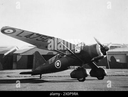 AEREI E PALLONI USATI DA ALCUNI DEI PIONIERI AEREI CONTEMPORANEI A SAMUEL FRANKLIN CODY. - Un monoplano Westland Lysander a terra di fronte ad alcuni hangar Foto Stock