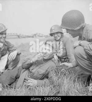 Fotografia che mostra i soldati russi e americani che riposano sulle rive del fiume Elba vicino a Torgau dopo che la i Armata americana si era legata alla i Armata Ucraina russa nell'aprile-maggio 1945, Europa nordoccidentale. Foto Stock