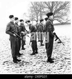 Impiegati e soldati dell'esercito britannico conducono un'ispezione di una pistola Tommy. Foto Stock