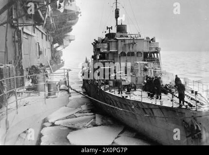 LA ROYAL NAVY DURANTE LA SECONDA GUERRA MONDIALE - la corvetta inglese classe Flower HMS HONEYSUCKLE che si affianca alla portaerei HMS TROMBETTIERE (da cui è stata scattata la fotografia) a Kola Inlet, che è piena di branco di ghiaccio Royal Navy, TROMBETTIERE (HMS), Royal Navy, HMS Honeysuckle, Sloop, (1915) Foto Stock