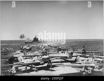 La HMS Valiant, una nave da battaglia, conduce un tiro di esercitazione da 15 pollici mentre viene osservata dal ponte di volo della HMS Illustrious. I Fairey Fulmars del 806 Naval Air Squadron operano in primo piano durante le esercitazioni. Foto Stock