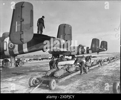 ROYAL AIR FORCE: 2ND TACTICAL AIR FORCE, 1943-1945. - Gli equipaggi di terra della RAF e della marina olandese si preparano a caricare bombe MC da 500 lb nel North American Mitchell Mark IIS del No. 320 Squadron RAF, in condizioni invernali a B58/Melsbroek, Belgio, 31 dicembre 1944 Royal Air Force, Royal Air Force, Royal Air Force Regiment, Sqdn, 98, Royal Air Force, 2 Group, Royal Air Force, unità di manutenzione, 201 Foto Stock