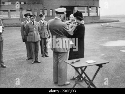 Il decenne Marian Edward Bełc riceve la Distinguished Flying Cross di suo padre, l'ufficiale pilota Bełc, dal commodoro W. H. Dunn durante una cerimonia alla RAF di Grangemouth il 21 settembre 1942. Negativo fotografico. Foto Stock