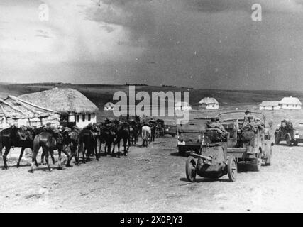 L'ESERCITO TEDESCO SUL FRONTE ORIENTALE, 1941-1945 - cavalleria tedesca, camion e un cannone anticarro trainato da 37 mm avanzano attraverso un villaggio russo in Ucraina, 1942 Foto Stock