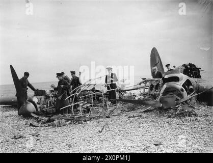 LA BATTAGLIA DELLA GRAN BRETAGNA 1940 - civili e personale della RAF perlustrano i resti bruciati di un Heinkel He 111 che si è schiantato su una spiaggia della costa meridionale, 11 luglio 1940 Foto Stock