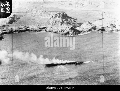 OPERAZIONI DELLA ROYAL AIR FORCE A MALTA, GIBILTERRA E NEL MEDITERRANEO, 1940-1945. - Sommergibili tedeschi tipo VIIC, U-617, in fiamme e giacenti sul lato del porto dopo essere stati spiaggiati al largo della costa marocchina vicino a Melilla, a causa dei danni subiti in un attacco da due Vickers Wellington Mark VIIIs di Gibilterra del No. 179 Squadron RAF, la mattina presto del 12 settembre 1943. Fotografia tratta da un Lockheed Hudson del No. 48 Squadron RAF, uno dei numerosi aerei inviati da Gibilterra per continuare l'attacco. Tutto l'equipaggio dell'U-617 raggiunse la costa in sicurezza, e alla fine fu destr Foto Stock