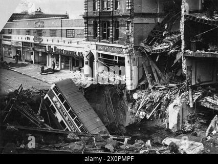 THE LONDON BLITZ 1940 - 1941 - foto scattata Balham 15.10.40.alle 20:02 del 14 ottobre 1940 una bomba piercing semi-corazzata da 1400 kg sganciata sulla stazione della metropolitana di Balham, causando l'enorme cratere mostrato qui. La bomba esplose a 32 metri sotto il passaggio che univa le due piattaforme. Un autobus numero 88, viaggiando in nero, ha guidato dritto nel cratere. Circa 600 persone stavano riparando nella stazione quando la bomba è esplosa. L'acqua, il gas e la rete fognaria sono stati tutti rotti e molte persone sono annegate durante l'allagamento della stazione. 68 persone sono state uccise Foto Stock