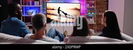 Guardare la TV insieme in coppia con la famiglia e gli amici in camera Foto Stock