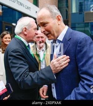 L'ex Taoiseach Bertie Ahern incontra e stringe la mano con l'attuale leader di Fianna Fail e Tanaiste Micheal Martin mentre arriva al Fianna Fail Ard Fheis, al Royal Convention Centre di Dublino. Data foto: Sabato 13 aprile 2024. Foto Stock