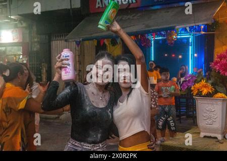 2 donne cambogiane ricoperte di polvere di talco / polvere per bambini durante il festival cambogiano del capodanno. Phnom Penh, Cambogia. Aprile 2024. © Kraig Lieb Foto Stock