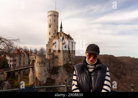 Attraente viaggiatore maturo di fronte al famoso Castello del Liechtenstein vicino a Honau in Germania. Foto Stock