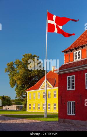 La bandiera danese ondeggia sulla caserma reale al tramonto a Copenaghen, Danimarca, al Parco Kronprinsessegade Foto Stock