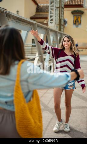 Due amici si salutano e si incontrano di nuovo in una strada a Malaga, Spagna. Foto Stock