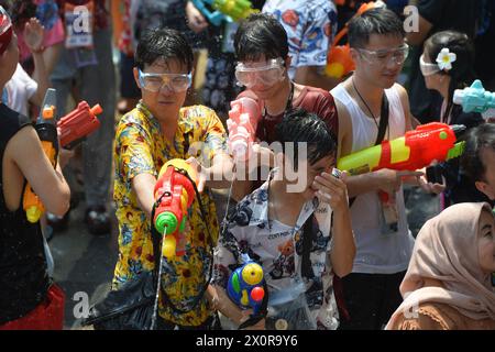 Bangkok, Thailandia. 13 aprile 2024. Le persone si spruzzano l'acqua l'una sull'altra in occasione del festival Songkran a Bangkok, Thailandia, 13 aprile 2024. Il festival di Songkran, il tradizionale Capodanno tailandese, viene celebrato dal 13 al 15 aprile di ogni anno, durante il quale le persone esprimono saluti spruzzando acqua l'una sull'altra. Crediti: Rachen Sageamsak/Xinhua/Alamy Live News Foto Stock